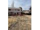 Backyard view featuring a two-story house with a wood deck and patio surrounded by a sparse lawn at 16835 E Harvard Pl, Aurora, CO 80013