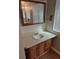 A well-lit bathroom featuring wood cabinets, a cream countertop, and wood-look flooring at 16835 E Harvard Pl, Aurora, CO 80013