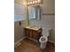 Bathroom with decorative wood-look vanity, medicine cabinet, and white toilet at 16835 E Harvard Pl, Aurora, CO 80013