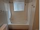 Full white tiled bathtub with shower and window that provides natural light at 16835 E Harvard Pl, Aurora, CO 80013