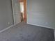 Bedroom view with gray walls, gray carpeting, white trim, and open door to hallway and bathroom at 16835 E Harvard Pl, Aurora, CO 80013