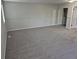 Spacious carpeted bedroom featuring a closet with mirrored doors and a separate entry door at 16835 E Harvard Pl, Aurora, CO 80013