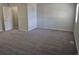 Carpeted bedroom showcases two doors, a window, and a neutral color scheme at 16835 E Harvard Pl, Aurora, CO 80013