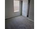 Bedroom with gray walls, gray carpeting, a window with blinds and a sliding closet door at 16835 E Harvard Pl, Aurora, CO 80013