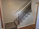Carpeted staircase with white and black railing provides access to the upper level at 16835 E Harvard Pl, Aurora, CO 80013