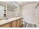 Clean bathroom featuring dual sinks, a large mirror, and stylish gray wood-look flooring at 5255 Memphis St # 224, Denver, CO 80239