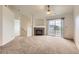 Bright living room featuring a stone fireplace, plush carpet, and sliding glass doors to balcony at 5255 Memphis St # 224, Denver, CO 80239