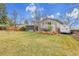 Large backyard with a well-kept lawn, patio seating, mature trees, and a camper in the driveway at 7148 S Dahlia Ct, Centennial, CO 80122