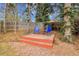 Cozy backyard with a small deck featuring blue chairs and a small table under mature trees at 7148 S Dahlia Ct, Centennial, CO 80122