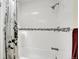 Modern bathroom with white tiled walls, black accent tiles, and a shower-tub combination at 7148 S Dahlia Ct, Centennial, CO 80122