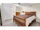 Bedroom featuring a wooden bed frame, closet, dresser, and light laminate floors at 7148 S Dahlia Ct, Centennial, CO 80122