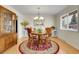 Bright dining room featuring hardwood floors, a chandelier, and large windows for natural lighting at 7148 S Dahlia Ct, Centennial, CO 80122