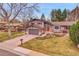 Charming two-story home with grey wood siding, a landscaped yard, a driveway, and mature trees at 7148 S Dahlia Ct, Centennial, CO 80122