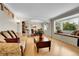 Inviting living room with hardwood floors, comfortable seating, a bay window, and views of the dining room at 7148 S Dahlia Ct, Centennial, CO 80122