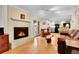Living room with fireplace, wood floors, and open layout to the kitchen and dining areas at 7148 S Dahlia Ct, Centennial, CO 80122