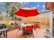 Relaxing patio with a table, chairs, grill, and hot tub all shaded by a bright red umbrella at 7148 S Dahlia Ct, Centennial, CO 80122