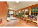 Bright sun room with brick accent wall, terra cotta tile floor and views of the backyard at 7148 S Dahlia Ct, Centennial, CO 80122