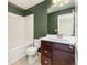 This bathroom features wood vanity, a white countertop, toilet, and shower with white tile at 10154 Belvedere Loop, Lone Tree, CO 80124