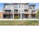 Stylish townhomes with contemporary exteriors, showcasing private balconies and inviting entryways, set against a lush green lawn at 10154 Belvedere Loop, Lone Tree, CO 80124
