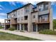 Modern townhome exteriors featuring balconies, covered entryways, and manicured front yards in a vibrant community at 10154 Belvedere Loop, Lone Tree, CO 80124