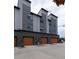 Three car garage with brown doors on a modern, gray townhome at 10154 Belvedere Loop, Lone Tree, CO 80124
