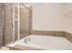 Bathroom featuring a soaking tub, separate glass shower and tiled walls at 3523 Brushwood Dr, Castle Rock, CO 80109
