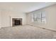 Bright living room featuring a stone fireplace and neutral carpet with a large window at 3523 Brushwood Dr, Castle Rock, CO 80109