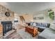 Open living room with stone fireplace, wood floors, a large sofa, and stairs to the second level at 14344 E Hawaii Cir # B, Aurora, CO 80012