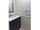 Stylish half bathroom with dark blue vanity, gold hardware, and marble countertop at 625 S Xenon Ct, Lakewood, CO 80228