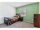 Cozy bedroom featuring carpet, a single bed, and a bright green accent wall at 625 S Xenon Ct, Lakewood, CO 80228
