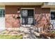 Close up of the townhome's brick front door with security screen and decorative wagon wheel at 625 S Xenon Ct, Lakewood, CO 80228