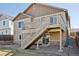 Stairs descending from the deck to the yard, featuring low-maintenance landscape and sliding door access to the home at 24437 E Powers Ave, Aurora, CO 80016