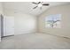Spacious carpeted bedroom featuring a ceiling fan, window and light-colored walls at 24437 E Powers Ave, Aurora, CO 80016