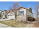 Side view of home featuring a two-car garage, stone accents, and low maintenance yard at 24437 E Powers Ave, Aurora, CO 80016
