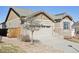 View of the home featuring a two-car garage, stone accents, and low maintenance yard at 24437 E Powers Ave, Aurora, CO 80016