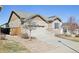 View of the home featuring a two-car garage, stone accents, and low maintenance yard at 24437 E Powers Ave, Aurora, CO 80016
