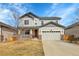 Charming two-story home featuring a well-maintained lawn, stone accents, and an attached two-car garage at 3310 Quicksilver Rd, Frederick, CO 80516