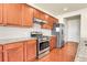 Contemporary kitchen includes stainless steel appliances, granite countertops, tile backsplash, and wood cabinets at 3310 Quicksilver Rd, Frederick, CO 80516