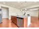 Modern kitchen island with granite countertop, stainless steel appliances, and hardwood floors at 3310 Quicksilver Rd, Frederick, CO 80516