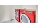 Laundry room with modern red washer and dryer appliances at 3310 Quicksilver Rd, Frederick, CO 80516