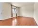 Bright living room features hardwood floors, a large window with curtains, and neutral wall paint at 3310 Quicksilver Rd, Frederick, CO 80516