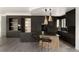 Modern kitchen with sleek black cabinetry, a stylish island with seating, and chic pendant lighting at 4935 E Preserve Ln, Greenwood Village, CO 80121