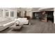 Open-concept living room with white sofa, concrete coffee table, and modern kitchen in the background at 4935 E Preserve Ln, Greenwood Village, CO 80121
