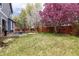 Spacious backyard with a small patio set and blooming trees creating a serene outdoor space at 12742 Vrain St, Broomfield, CO 80020