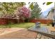 Landscaped backyard featuring a stone patio, lawn, and a dining set with a charming black and white outdoor rug at 12742 Vrain St, Broomfield, CO 80020