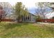 Spacious yard with a patio area and lawn furniture, framed by mature trees and a wooden fence at 12742 Vrain St, Broomfield, CO 80020