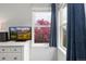 Bright bedroom featuring large windows with blue curtains and a TV on a white dresser at 12742 Vrain St, Broomfield, CO 80020