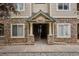 Townhome entrance featuring stone facade, covered entry, and well-lit access at 9692 W Coco Cir # 304, Littleton, CO 80128