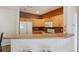 Kitchen features modern appliances, light wood cabinetry, and a breakfast bar for casual dining at 9692 W Coco Cir # 304, Littleton, CO 80128