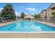 Resort-style pool area with lounge chairs, clubhouse, and lush landscaping at 9692 W Coco Cir # 304, Littleton, CO 80128